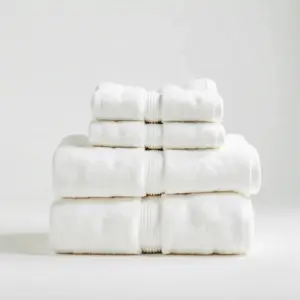 "Serviette de bain blanche pliée avec soin sur une surface propre, idéale pour pressing ou linge de maison haut de gamme"